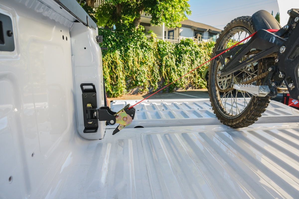 Ultimate Retractable Ratchet Strap on the Anchor Point mount in the rear corner of a Ford Ranger bed, strapping a dirt bike