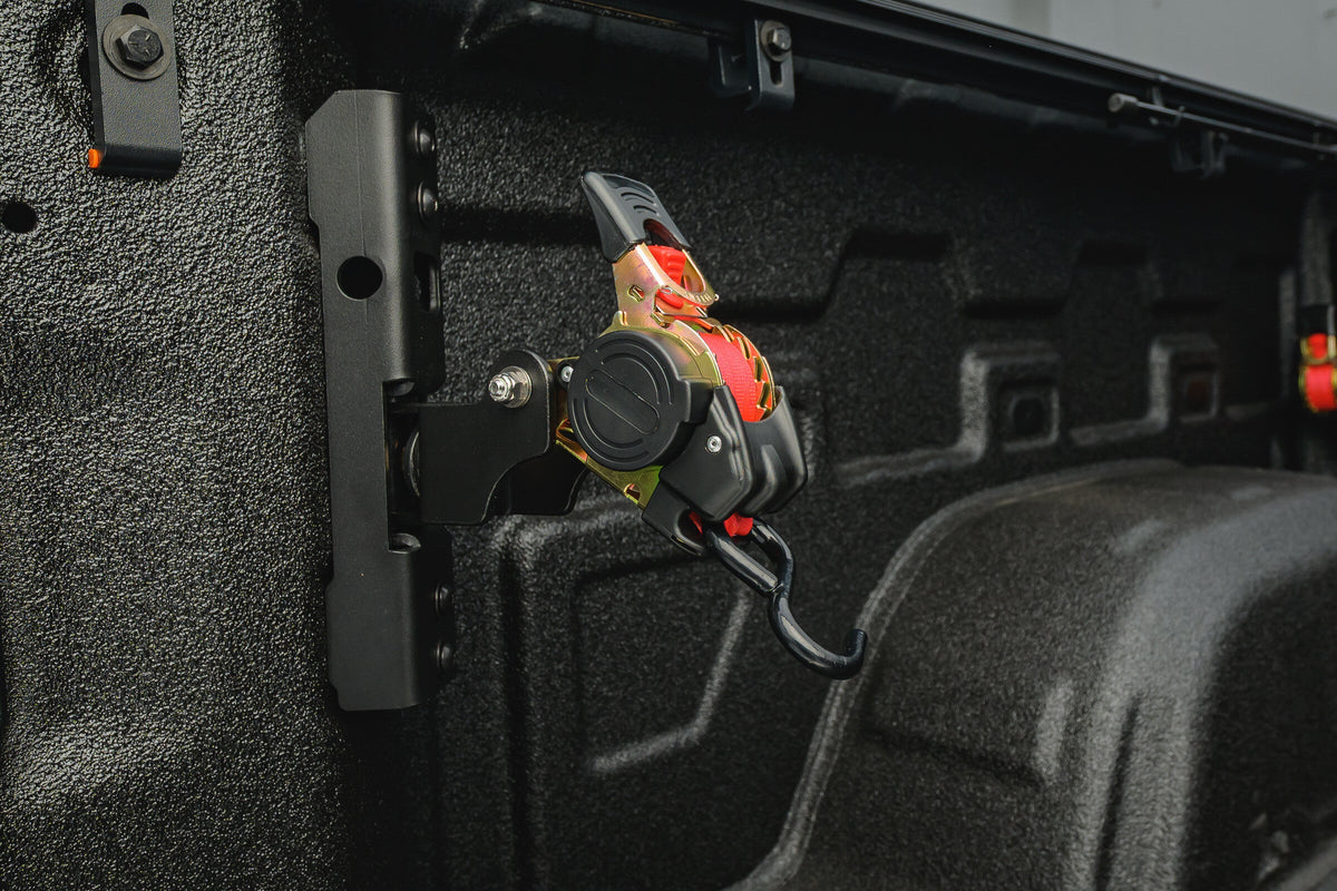 Close-up of the Ultimate Retractable Ratchet Strap stowed on the Chevy/GMC 2019+ bed mount