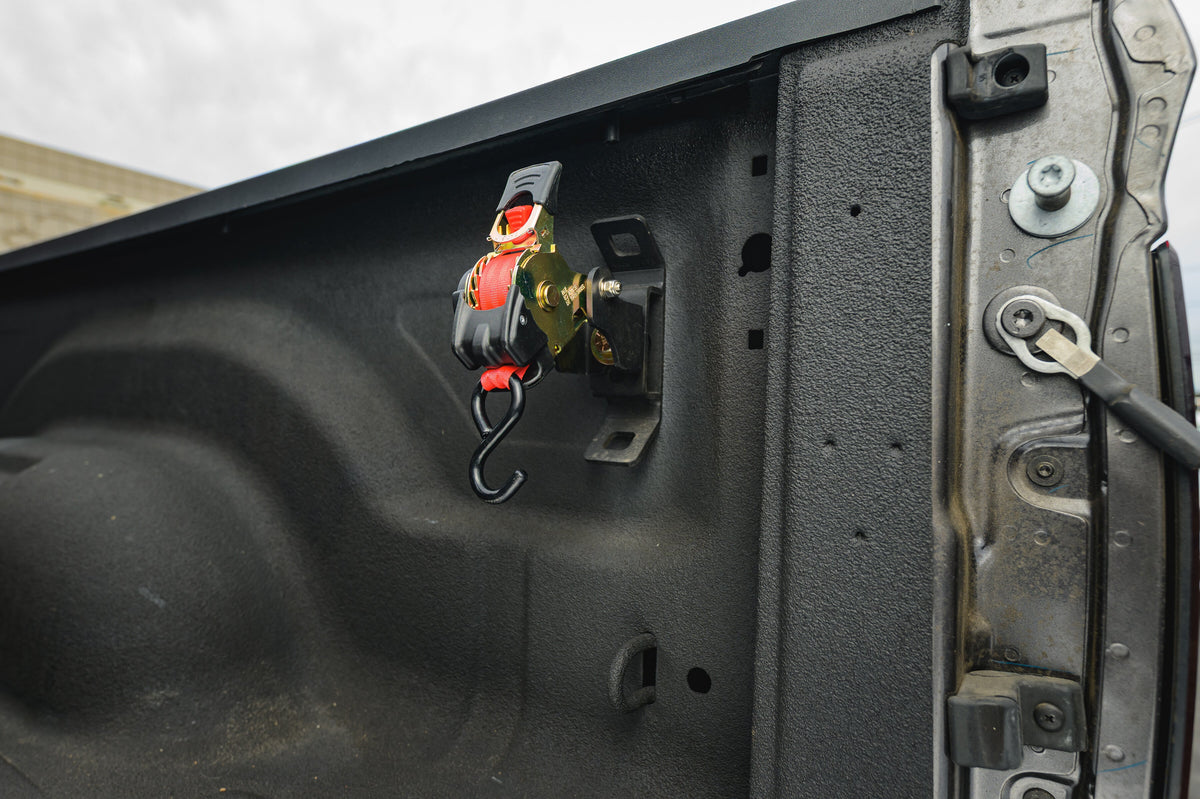 Ultimate Retractable Ratchet Strap stowed on the RAM 2019+ mount near the tailgate