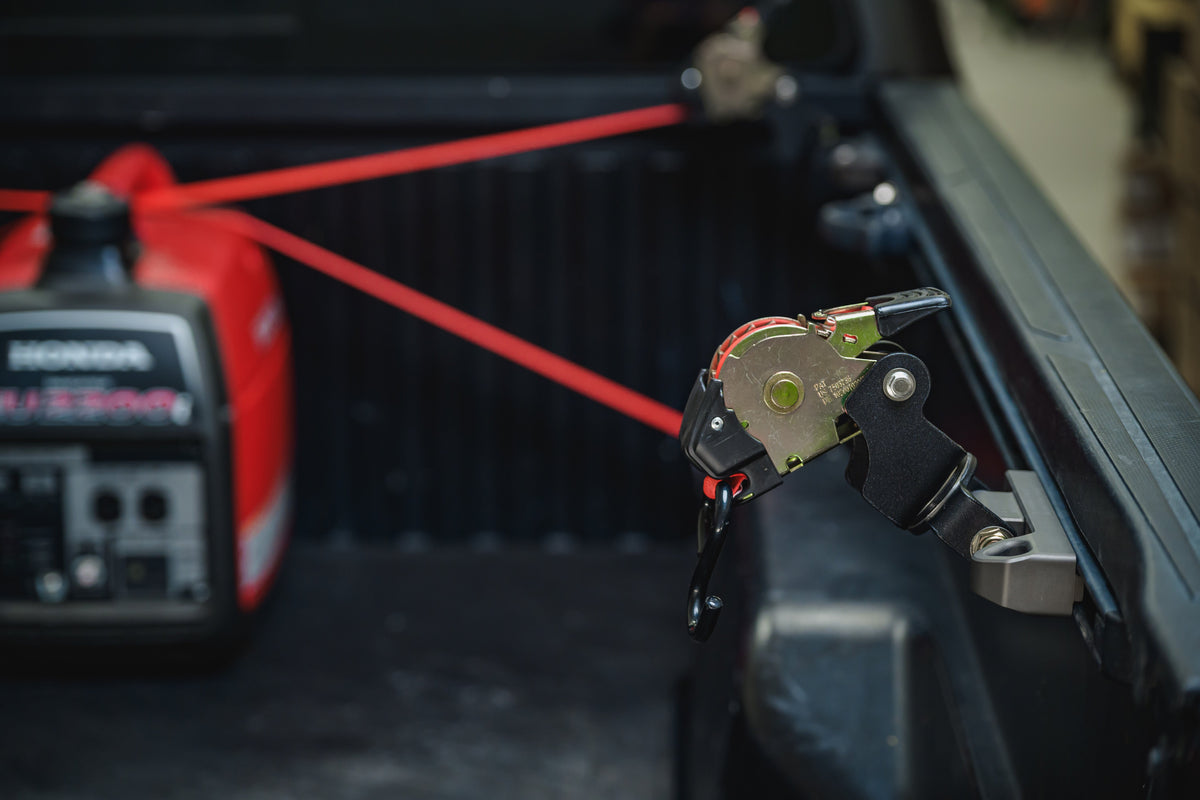 Ultimate Retractable Ratchet Strap on the Toyota bed rail mount securing a Honda generator in a Tacoma bed
