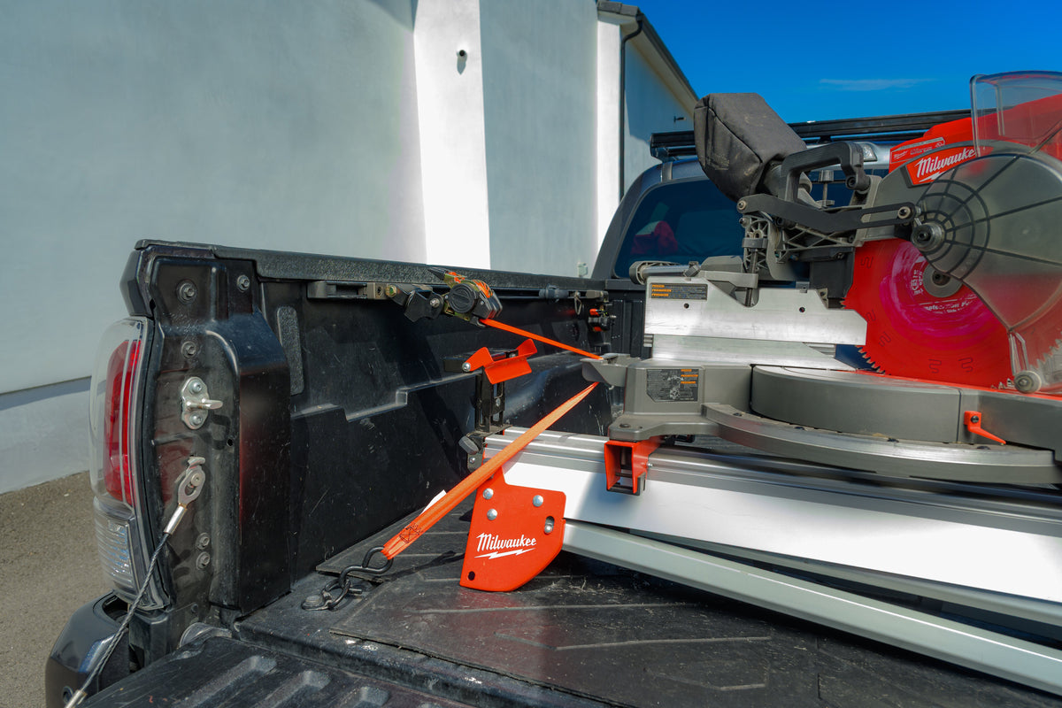 Ultimate Retractable Ratchet Straps holding a miter saw in a Tacoma bed, viewed from above the bed rail